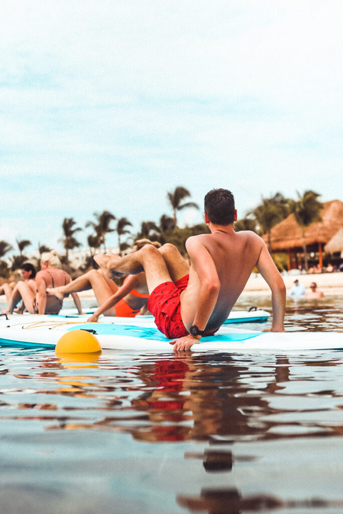 pic of us doing paddle board yoga at playa mujeres for the blog Are Excellence Collection Hotels the best?