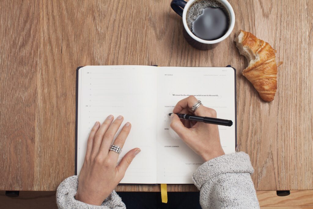 a photo of a person using a day planner, used in the blog on building a successful morning routine