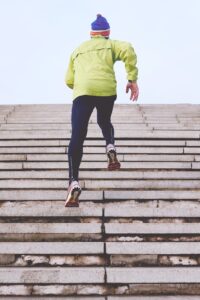 a person running up bleacher stairs during winter, a photo being used for a blog to stay fit this winter