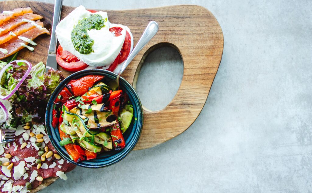 a photo of salmon and veggies on a wood board, prepared for the keto diet