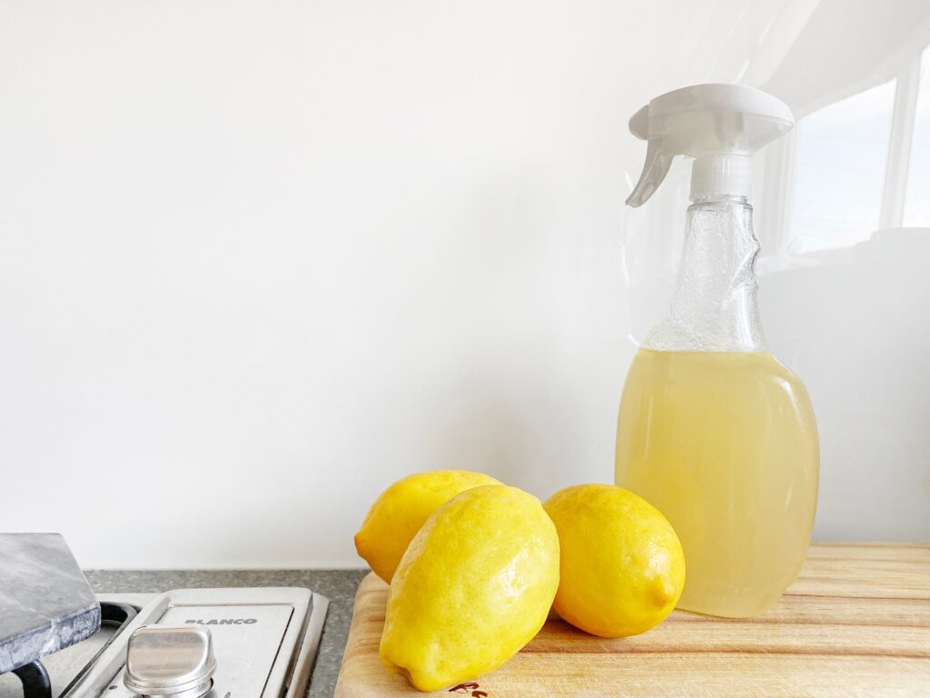 An image of lemons sitting on a counter top with a cleaning bottle behind them for the blog post about cleaning products for pet-friendly homes